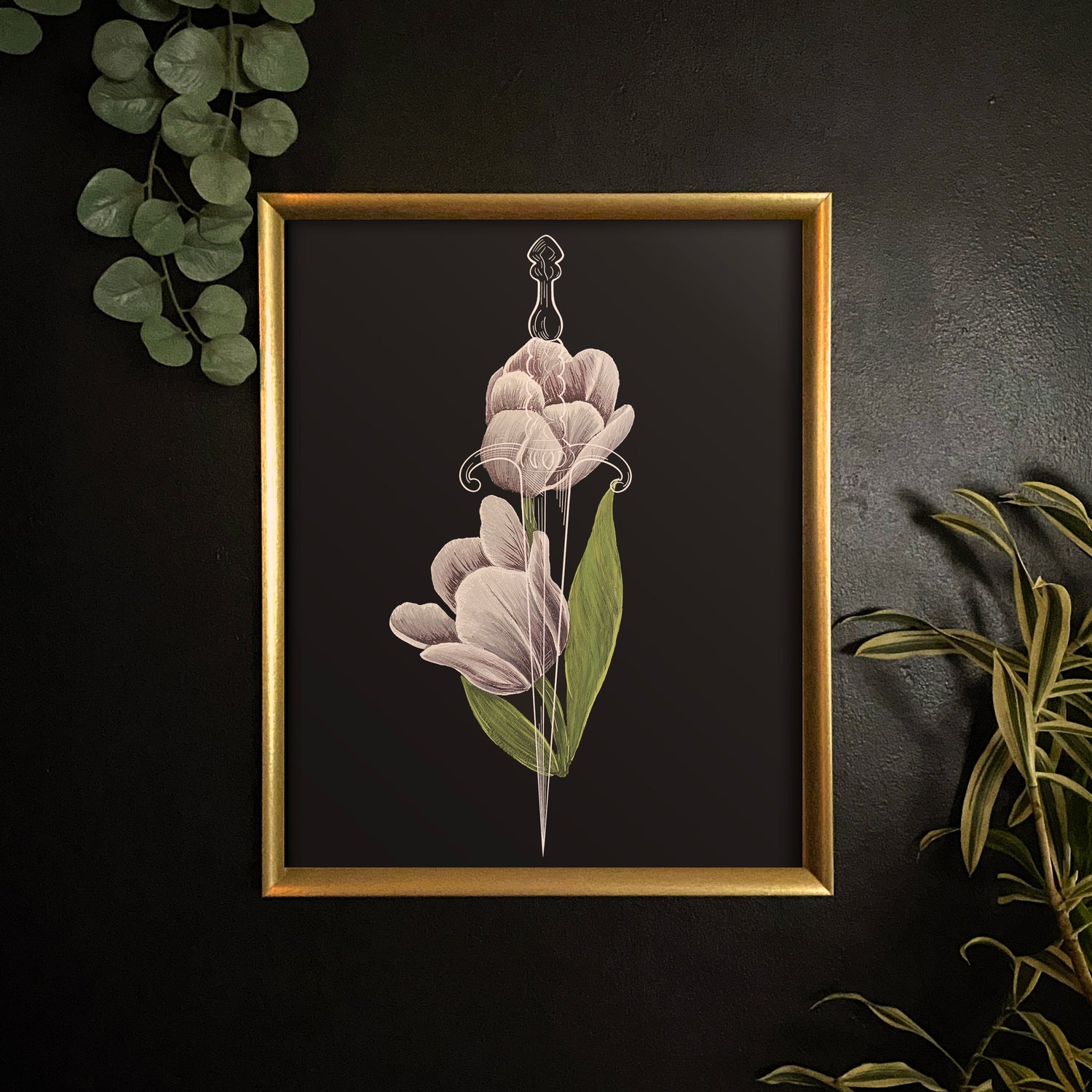 print of tulip in gold frame on black wall amongst live plants